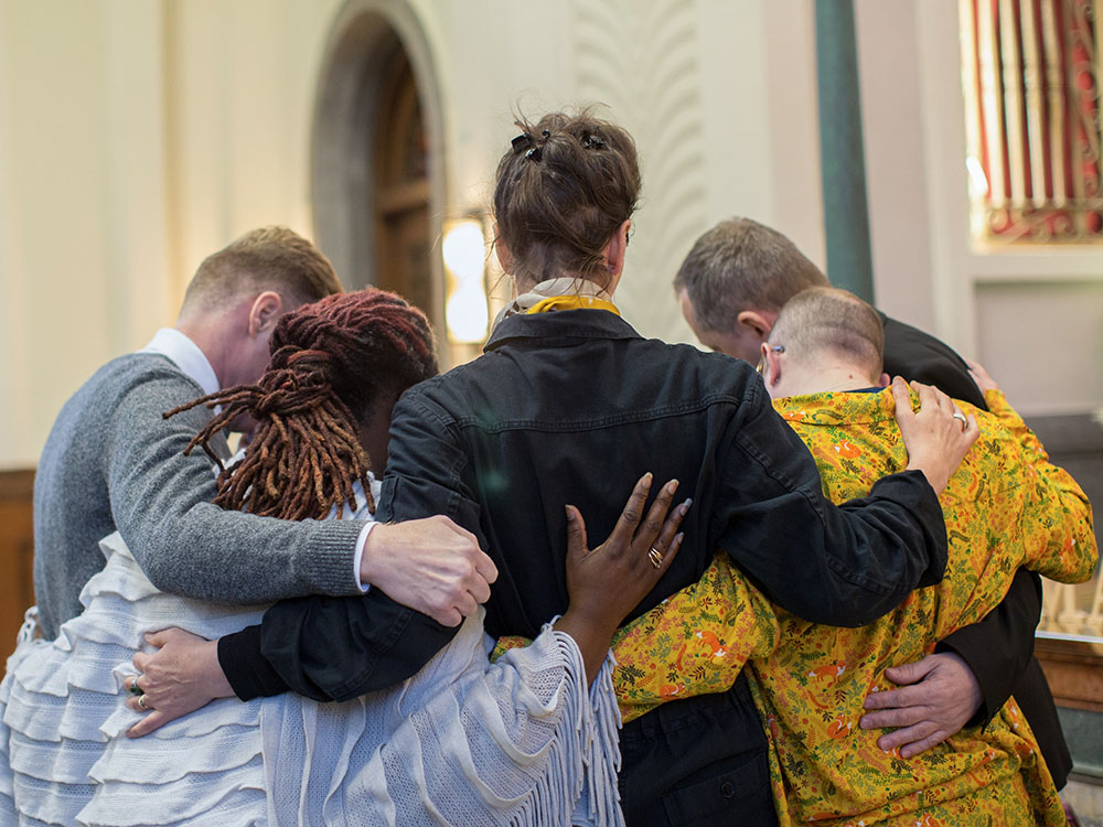 group of people holding each other in church for grieving